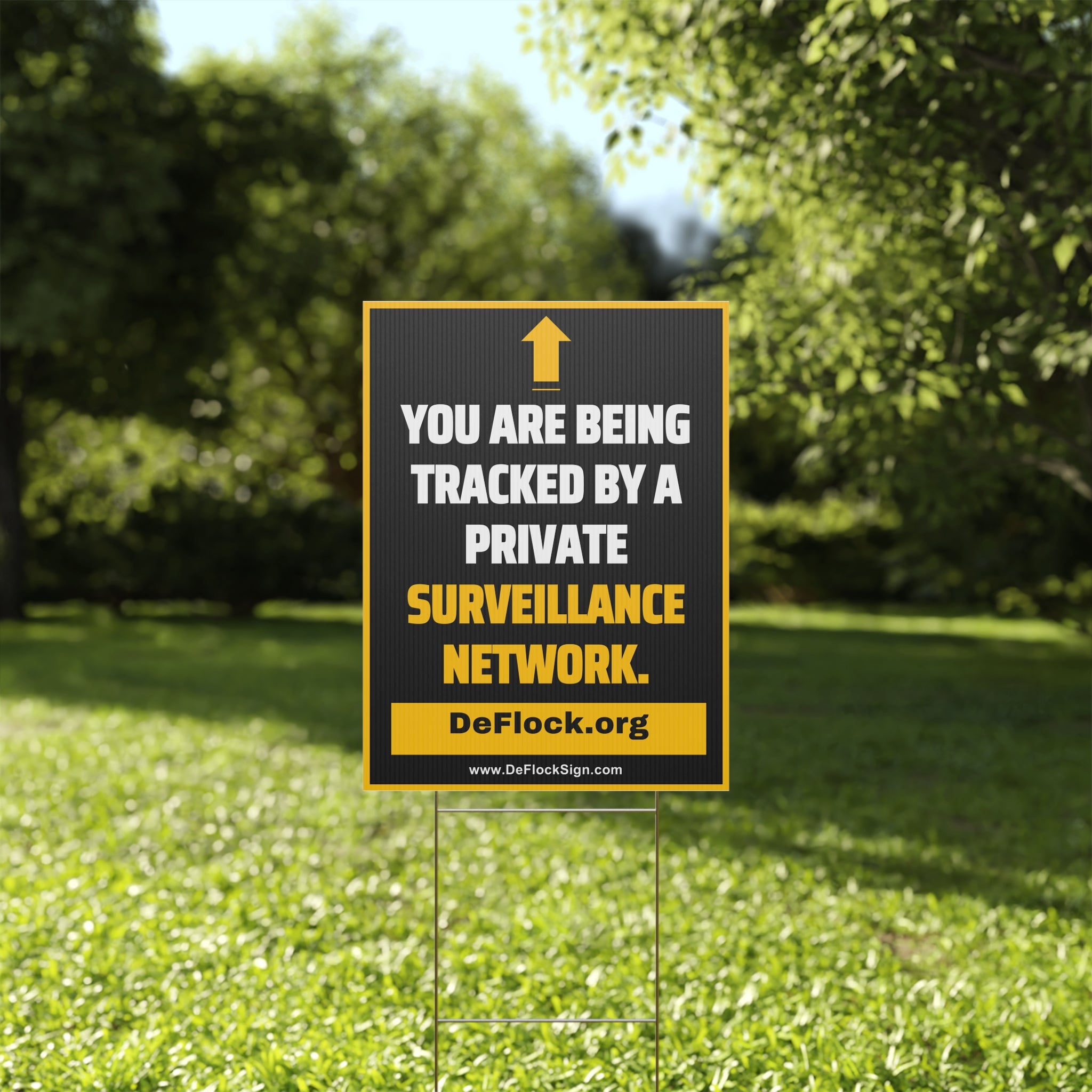 Yard sign with an arrow pointing upwards, and a message that says "You are being tracked by a private surveillance network" to indicate that above the sign is a surveillance camera.