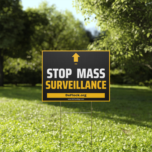 Yard sign with an arrow pointing upwards, and a message that says "Stop Mass Surveillance" to indicate that above the sign is a surveillance camera.