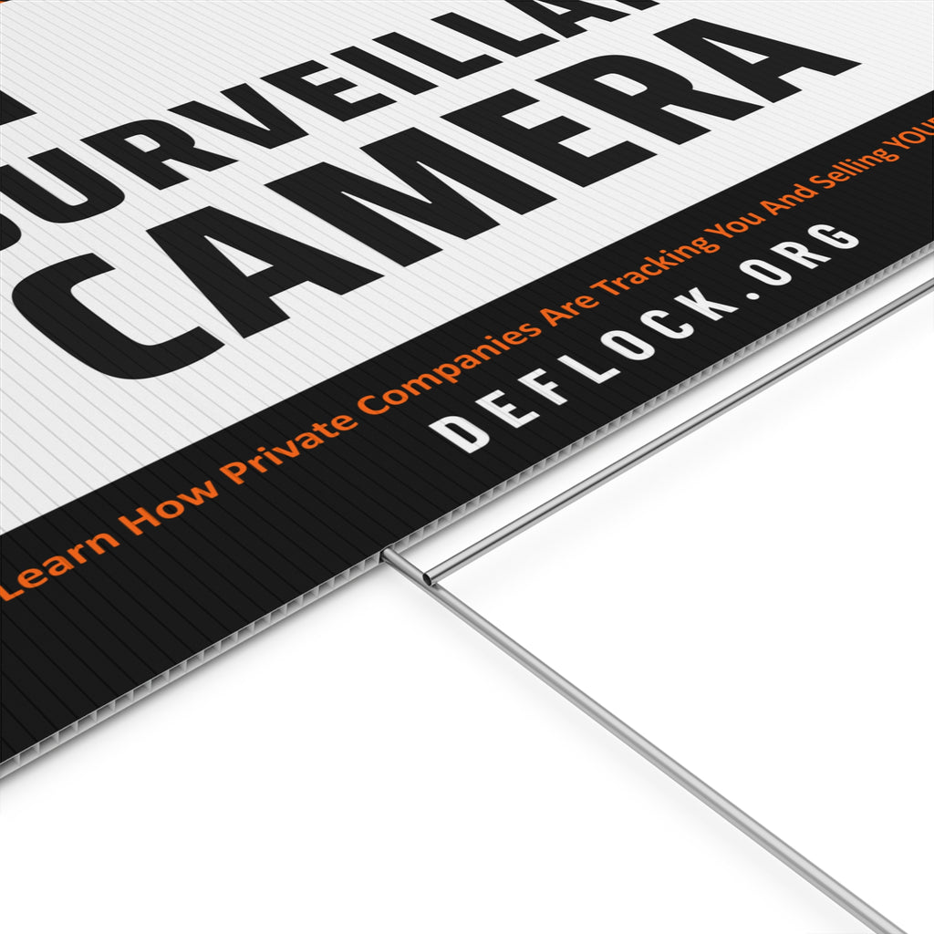 Yard sign with an arrow pointing upwards, and a message that says "AI Surveillance Camera" to indicate that above the sign is a surveillance camera.